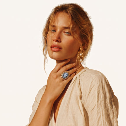 Model wearing oval floral cameo statement ring with ornate border and pearl accents | Olaty