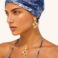 Model wearing Blooming Garden floral necklace and drop earrings with layered gold necklaces | Olaty