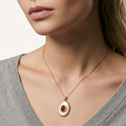 Close-up of model wearing amber cameo pendant necklace with mother-of-pearl and sparkling accents | Olaty