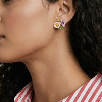 Close-up of model wearing enamel wildflower stud earring with colorful floral and green leaf details | Olaty