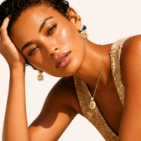 Close-up model wearing golden square Zirconia necklace and matching geometric drop earrings | Olaty