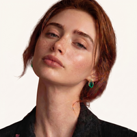 Model wearing emerald Liuli glass stud earrings with sculptural gold-tone and Zirconia detailing | Olaty