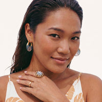 Model wearing colorful blue and pink ripple hoop earrings with gold-tone upper detail | Olaty