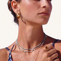 Model wearing amber resin drop earrings with layered necklaces and gold jewelry | Olaty