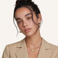 Model wearing square zirconia pendant necklace and matching drop hoop earrings | Olaty