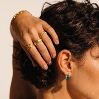 Close-up of model wearing emerald Liuli glass stud earring with sparkling Zirconia accents | Olaty
