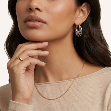 Close-up of model wearing blue and pink enamel ripple hoop earring with layered curved design | Olaty