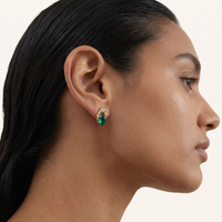 Profile close-up of model wearing emerald Liuli glass stud earring with gold-tone and Zirconia detailing | Olaty