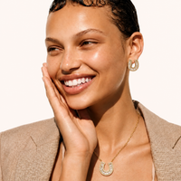 Model wearing gold horseshoe crystal necklace and matching earrings | Olaty