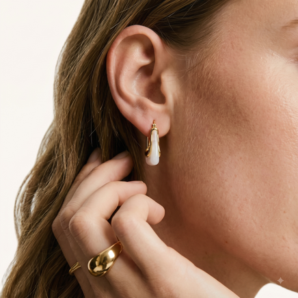 Close-up of model wearing liquid curve white resin hoop earring with sculptural gold-tone frame | Olaty
